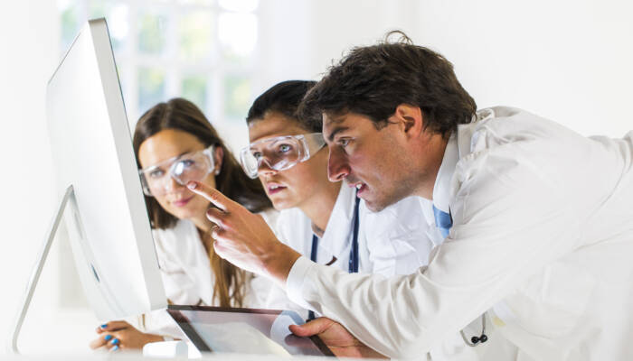 Team of doctors working in laboratory....checking data on computer monitor,man using digital tablet