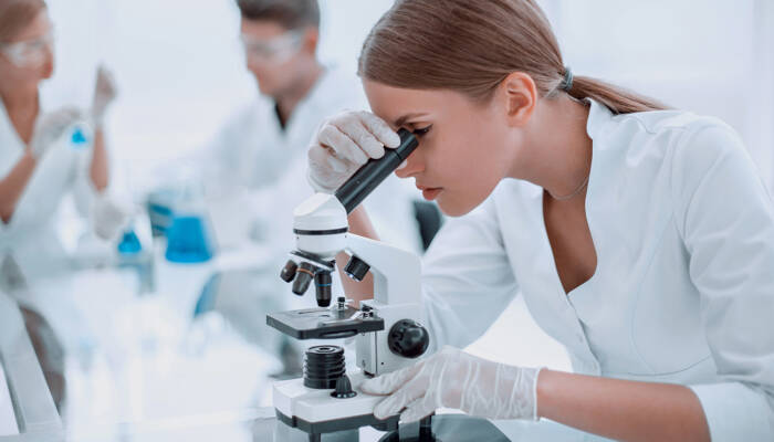 female scientist using a microscope in a chemical laboratory close up. female scientist using a microscope in a chemical laboratory